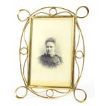 A LATE VICTORIAN BRASS WIREWORK PICTURE FRAME WITH EASEL SUPPORT, 23CM H X 17.5CM W