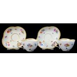 A PAIR OF MEISSEN LOBED CUPS AND SAUCERS PAINTED WITH FLORAL SPRIGS AND INSECTS, 13CM DIAM,