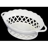 AN ENGLISH CREAMWARE RETICULATED OVAL BASKET WITH TWIG HANDLES, 26.5CM W, CIRCA 1800 (CRACKED)