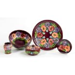 A GROUP OF MOORCROFT PANSY ON MAROON PATTERN POTTERY COMPRISING BOWL, PLATE DISH, VASE AND BOWL