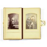 PHOTOGRAPHS. A LATE VICTORIAN LEATHER ALBUM OF CABINET PORTRAITS WITH LINEN HINGED, CHROMOLITHOGRAPH