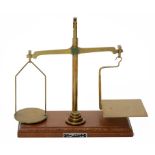 AN ENGLISH BRASS BEAM SCALE, EARLY 20TH C beam stamped CLASS TO B G TO WEIGH 8OZ, on lightwood