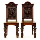 A PAIR OF VICTORIAN CARVED OAK HALL CHAIRS