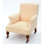 A VICTORIAN ARMCHAIR ON TURNED LEGS AND BRASS CASTORS