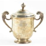 A VICTORIAN SILVER CUP AND COVER WITH FLYING SCROLL HANDLES ENGRAVED AT LATER DATE WITH AN