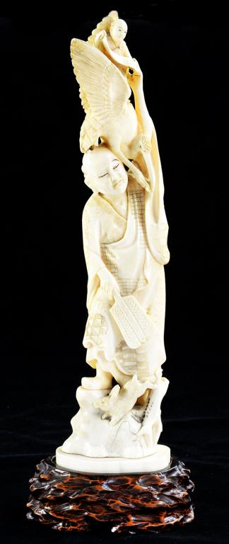 A JAPANESE IVORY CARVING OF A MAN, A BOY ON THE BACK OF A BIRD ALIGHTING ON HIS SHOULDER, A RABBIT