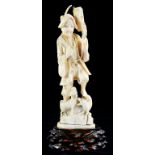 A JAPANESE IVORY CARVING OF A MAN CARRYING A LANTERN, TWO DOGS AT HIS FEET, 24CM H, MEIJI PERIOD,