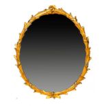 A GEORGE III GILTWOOD MIRROR, C1800 the leafy oval frame bound with ribbons, 89 x 70cm ++Old