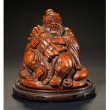 A CHINESE BAMBOO CARVING OF AN IMMORTAL seated with a bundle of faggots, 15cm h, wood stand ++In