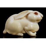 A JAPANESE IVORY NETSUKE OF A HARE, OSAKA SCHOOL, EDO/MEIJI PERIOD, 19TH C unsigned, 5.2cm l A