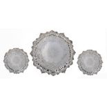 A SET OF THREE GEORGE II ROCOCO SILVER SALVERS the field engraved with armorials in flat chased