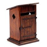 AN EARLY 20TH CENTURY CARVED AND STAINED WOOD NOVELTY SMOKERS CABINET IN THE FORM OF AN OUTSIDE '