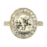 A DIAMOND CLUSTER RING with larger central collet set round brilliant cut diamond and diamond