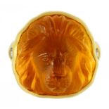 A DIAMOND RING set with a Lalique style amber glass lion mask relief, in gold, maker's mark and 18K,