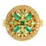 AN EMERALD AND DIAMOND RING of circular design with central openwork cluster of round and larger