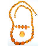 A NECKLACE OF FACETED AMBER GLASS BEADS AND SEVERAL SIMILAR LOOSE BEADS