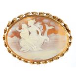 A CAMEO BROOCH, THE OVAL SHELL CARVED WITH CLASSICAL FIGURES ON A DOLPHIN, GOLD MOUNT