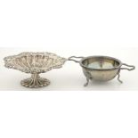 AN ELIZABETH II SILVER TEA STRAINER AND STAND, 12CM OVER HANDLES, BIRMINGHAM 1962 AND A PIERCED