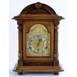 A GERMAN WALNUT BRACKET CLOCK OF ARCHITECTURAL STYLE WITH BREAKARCHED BRASS DIAL FLANKED BY REEDED