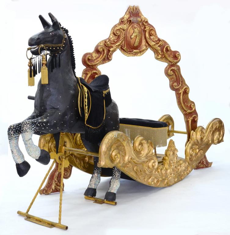 A PAINTED AND GILTWOOD AND PAPIER MACHE THEATRICAL HORSE AND SLEIGH, WITH ORNATE ARCH, REARING HORSE