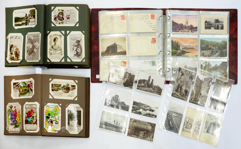 A COLLECTION OF POSTCARDS IN TWO ALBUMS AND A MODERN BINDER, MAINLY EARLY 20TH C GREETINGS, WORLD