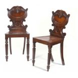 A PAIR OF VICTORIAN CARVED MAHOGANY HALL CHAIRS, C1850 on reeded forelegs, 85cm h ++Seat of one