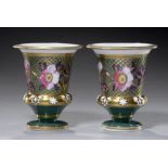 A PAIR OF ENGLISH PORCELAIN BEAKER MATCHPOTS, C1820 painted with flowers on a green and gilt ground,