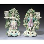 A PAIR OF DERBY SPRING CANDLESTICKS, C1770 of a seated boy or girl, with lamb or dog respectively,