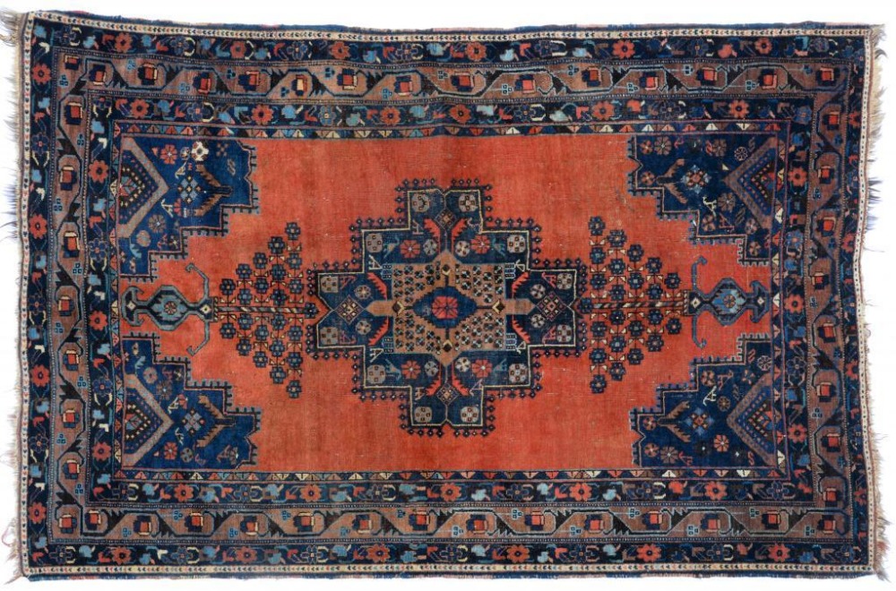 A NORTH WEST PERSIAN RUG. the madder field with a large polychrome central medallion with serrated