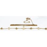 A DIAMOND BAR BROOCH IN GOLD, UNMARKED, 4.2G AND A GOLD AND CULTURED PEARL NECKLACE, MARKED 9CT