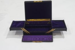 A late Victorian leather jewellery box with purple velvet interior,