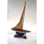 A 20th Century pond yacht, the hull painted silver with a black keep, on stand,