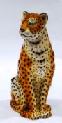 A large ceramic figure of a seated cheetah,