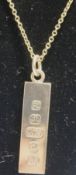 A 9 carat gold ingot pendant, London 1976, on chain, stamped '9ct' to the bolt ring,