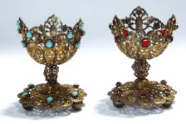 A pair of gilt metal paste set egg cups, 6.