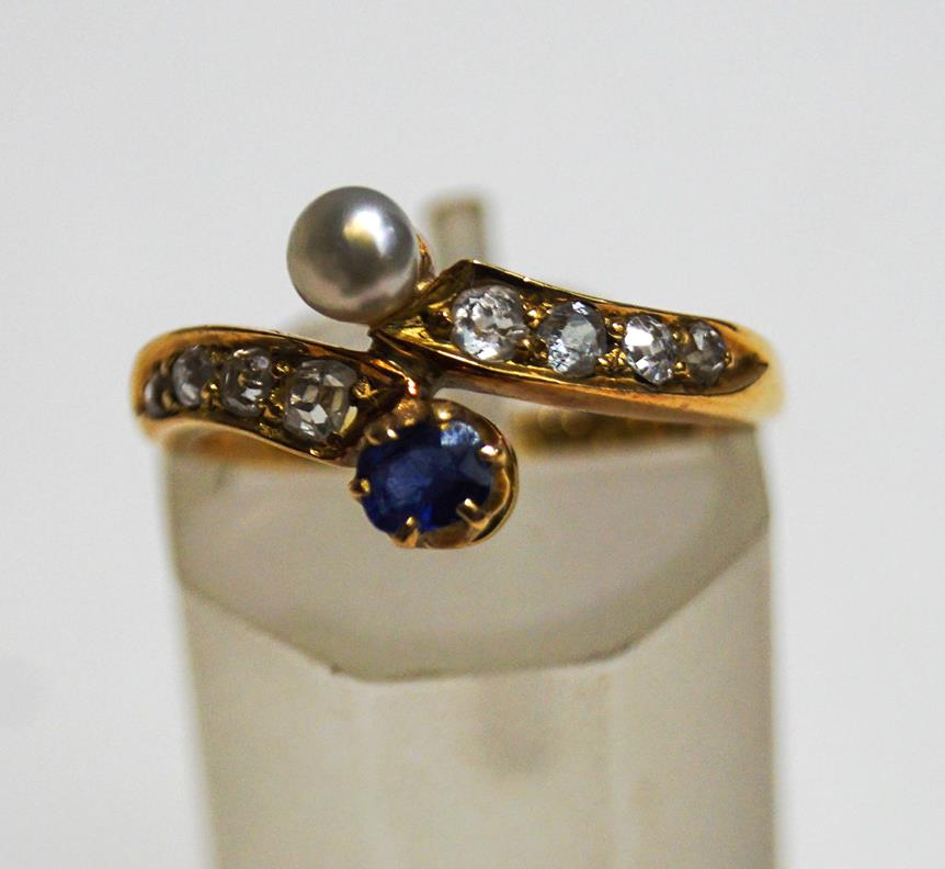 A late Victorian sapphire, diamond and pearl 18 carat gold cross over ring, Birmingham 1889,