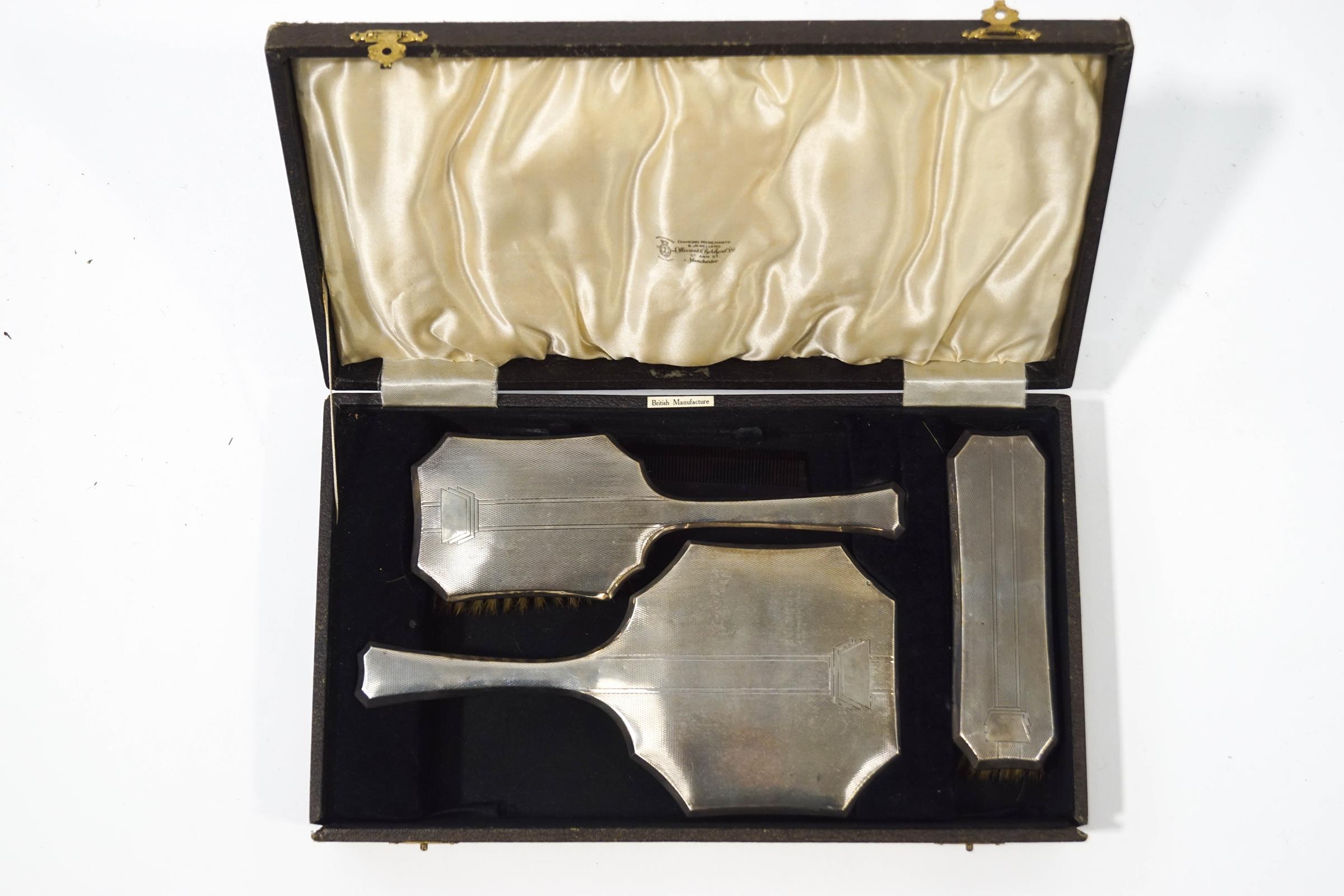 A silver three piece dressing table set, Birmingham 1939, comprising a hand mirror,