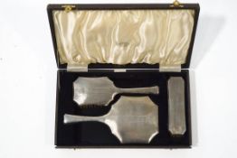 A silver three piece dressing table set, Birmingham 1939, comprising a hand mirror,