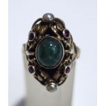A cabochon emerald set ring, with red stone and seed pearl points, probably Austro Hungarian,