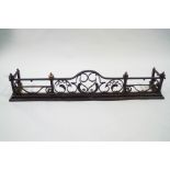 A cast and wrought iron fender with arched centre section,