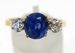 A modern 18ct gold, sapphire and diamond three stone ring,