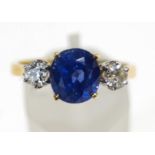 A modern 18ct gold, sapphire and diamond three stone ring,