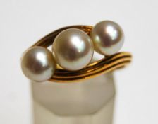 A Mikimoto three stone cultured pearl ring, stamped makers mark and 'K14',