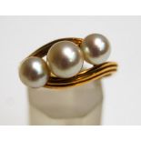 A Mikimoto three stone cultured pearl ring, stamped makers mark and 'K14',