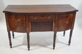 A 19th Century mahogany bow fronted sideboard, the central drawer above a tambour cupboard,