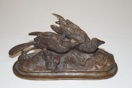 A bronze figure of two birds on an oval base,