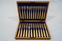 A set of twelve early 20th century plated fish knives and forks, with ivory handles,