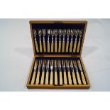 A set of twelve early 20th century plated fish knives and forks, with ivory handles,