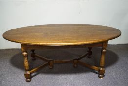 An oval oak dining table on turned baluster and block legs, joined by 'Y' shaped stretchers, 76.
