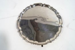 A silver salver, Birmingham 1930, of circular shaped outline with moulded rim, on four supports, 30.